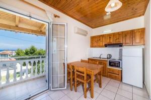 a kitchen with a wooden table and a balcony at Villa Georgia in Argassi