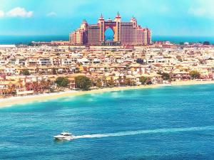 ein Boot im Wasser vor einer Stadt in der Unterkunft Atlantis View 1BR with Beachfront Access and Balcony in Dubai