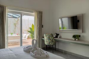 a bedroom with a bed with a television and a chair at Sitara Palace and Resort in Bhopal +33 photos