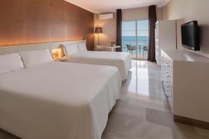 a hotel room with two beds and a television at Sol Guadalmar in Málaga