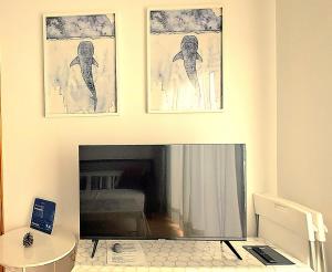 a living room with a television and two pictures on the wall at Restingolita in La Restinga