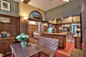 a large kitchen with a table and a bar at Caer Beris Hotel in Builth Wells