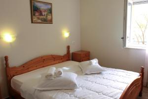 a bedroom with a large white bed with towels on it at Apartments Šuperba in Brodarica