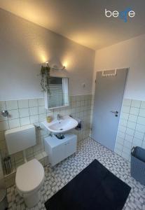 a bathroom with a white toilet and a sink at BEGE APARTMENTS WorkVibe Stay in Duisburg