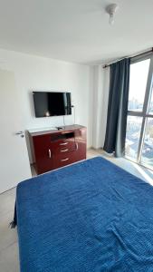 a bedroom with a blue bed and a tv at Cata in Villa María