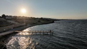 a pier in the middle of a body of water at Luxury Seafront Duplex Villa With Pool9 in Cesme