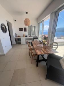 a dining room with a table and views of the ocean at Sea View Apartments in Herceg-Novi