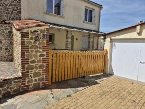 una valla de madera delante de una casa en Le Marsiluga Maison 12 pers à 6 min du Puy du Fou, en Saint-Mars-la-Réorthe