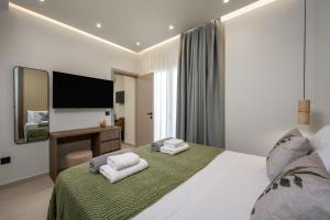Un dormitorio con una cama grande con dos toallas blancas. en Dia Luxury Apartments, en Rodas