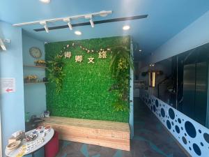 um quarto com uma parede verde com um banco em 墾丁卿卿文旅 em Hengchun South Gate