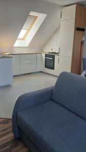 a living room with a blue couch in a kitchen at Białe Mewy- apartament in Stegna