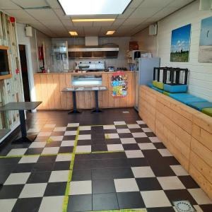 a kitchen with a checkered floor and a refrigerator at Mobilheim Budget 6p auf dem Campingplatz Scheldeoord in Baarland