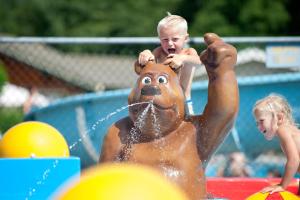 a young child playing with a toy bear in a pool at Mobilheim Budget 6p auf dem Campingplatz Scheldeoord in Baarland