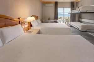 a hotel room with two beds and a balcony at Sol Guadalmar in Málaga