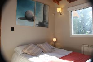 a bedroom with a bed with a painting on the wall at Casa Don Alfredo in San Carlos de Bariloche