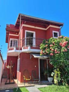 a red house with chairs and a balcony at Cantinho da Canastra in Água Boa