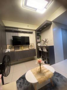 a living room with a table and a tv at BayBreeze Haven Nest in Manila +15 photos