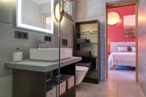a bathroom with a sink and a toilet and a bed at Casita Moritz in Costa Teguise +35 photos