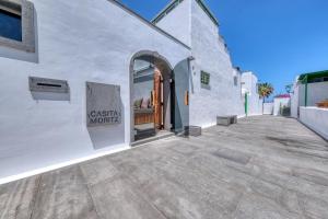 a white building with a sign on the side of it at Casita Moritz - Luxury - 1 min to the Beach By Lanzarote Vacation Homes in Costa Teguise