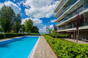 a swimming pool in front of a building at MyFlat Coral 61 Luxury Apartment in Siófok