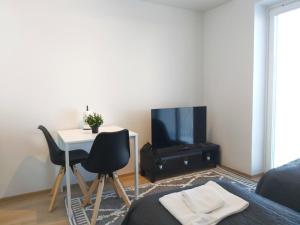 a living room with a tv and a table and chairs at Kotimaailma Apartments - keskustayksiö - Aleksanterinkatu in Tampere