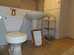 a bathroom with a toilet and a sink and a mirror at Hotel Empresarial in Los Ángeles