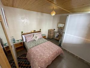 a bedroom with a bed with pink pillows at Hostel blue house Taghazout in Taghazout