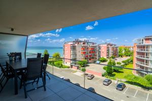a balcony with a table and a view of a city at MyFlat Coral 61 Luxury Apartment in Siófok