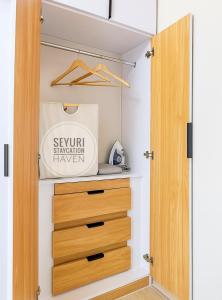 a closet with a wooden door and a drawer at Seyuri Staycation Haven in Manila +6 photos