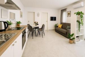 a kitchen and living room with a table and a couch at Olea apartments in Pobegi