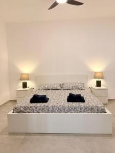 アグリジェントにあるLa casa delle parole 1の白いベッドルーム(ベッド1台、ナイトスタンド2台付)