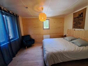 a bedroom with a bed and a chair in it at Evasion nature in Pontaix