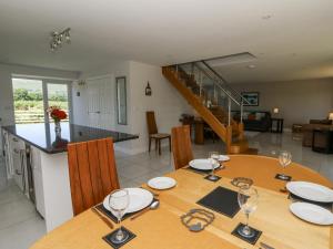 a dining room and kitchen with a table with wine glasses at Little Penrhosgoch Barn in Llandrindod Wells