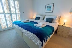 a bedroom with a large bed with towels on it at House 27 in Looe +22 photos