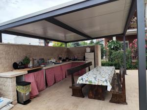a patio with a table and a kitchen with awning at Apartmani Petra in Umag