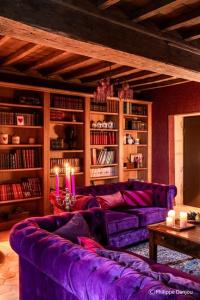 a living room with a purple couch and book shelves at Country Villa With Indoor Pool In Beaujolais in Romanèche-Thorins