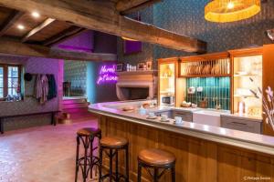 a bar with stools in a room with purple lighting at Country Villa With Indoor Pool In Beaujolais in Romanèche-Thorins