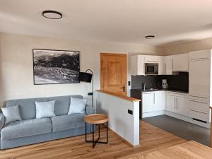 a living room with a couch and a kitchen at Appartement Fossa in Fiss