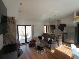 ein Wohnzimmer mit Couch und Küche in der Unterkunft Domek Loft z Balią Jacuzzi i sauną na wyłączność Dowspuda  + 6 Fotos