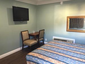 een slaapkamer met een bed, een tafel en een tv bij Park Motel in Los Angeles