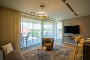 a living room with a couch and a television at MyFlat Coral 61 Luxury Apartment in Siófok