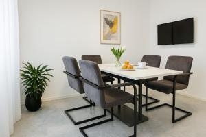 a dining room with a white table and chairs at Olea apartments in Pobegi