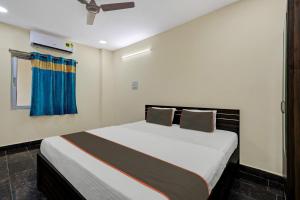 a bedroom with a large bed with a blue curtain at Hotel O AYWA STAYINN in Dhundgol
