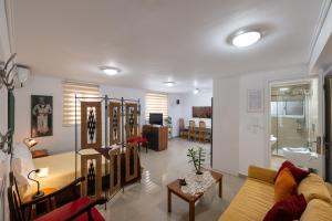 a living room with a couch and a table at Myrto lower ground floor studio in Kalamata