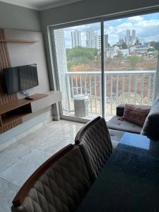 salon z kanapą i dużym oknem w obiekcie Flat alto padrão com piscina w mieście Campina Grande