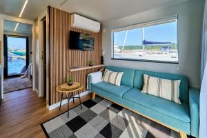 a living room with a blue couch and a window at Alma Flotante Muxía in Muxia