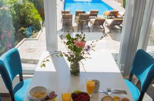 uma mesa branca com um vaso de flores e comida em Villa Jordan em Ohrid