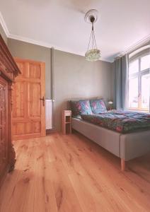 een slaapkamer met een bed en een houten vloer bij Kaiserhof Schwennenz in Grambow