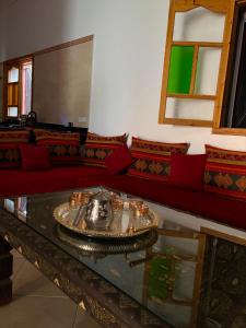 a living room with a red couch and a table at Dar Said Marrakech in Lalla Takerkoust +65 photos