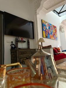 a living room with a large flat screen tv on the wall at Dar Said Marrakech in Lalla Takerkoust